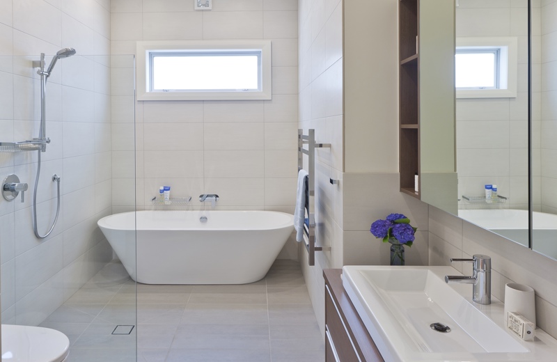 Keeping a bathroom floor clear of lips and steps, and cantilevering cabinetry off the wall, makes the whole room seem larger.
