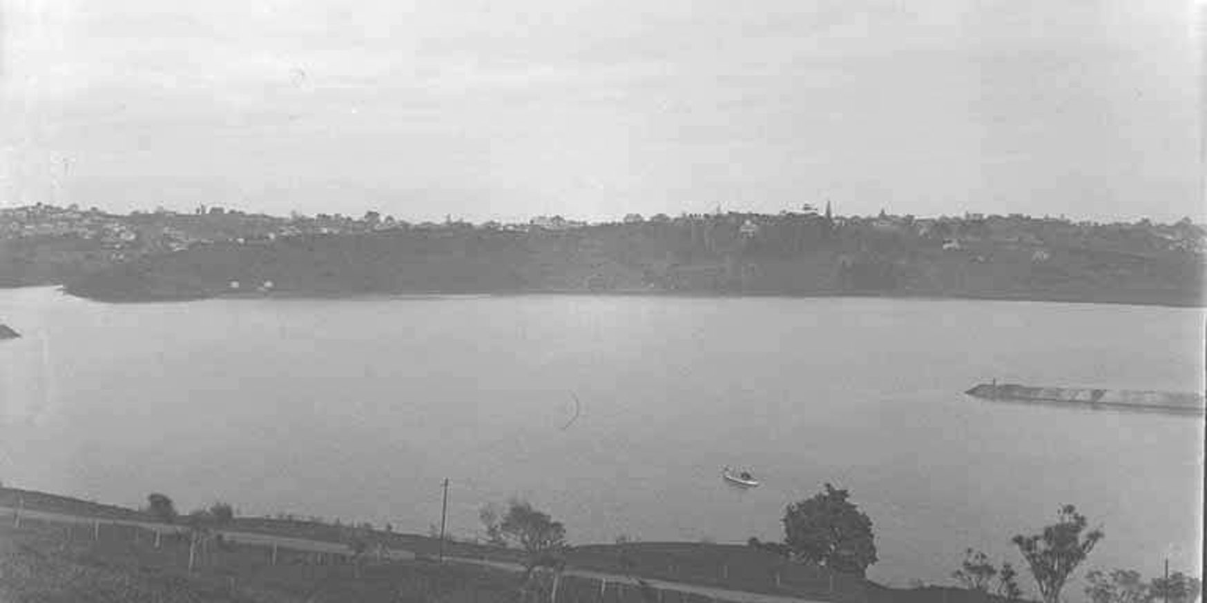 Looking south west over the Orakei Basin showing what is now Kepa Road (c. 1920)