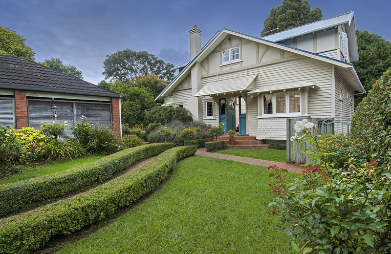 A 30s storybook home sitting on beautifully landscaped gardens.